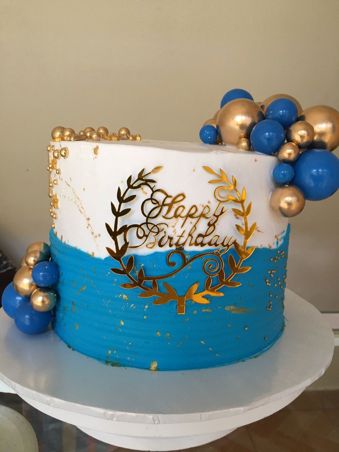 Blue and gold birthday cake made by Moh Bakes & Treats