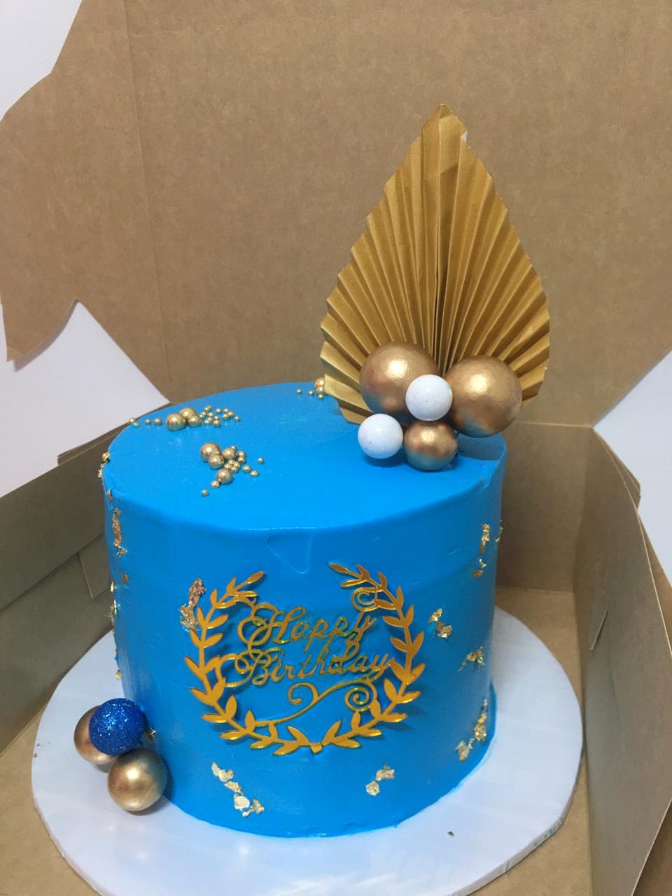 Simple blue and gold cake made by Moh Bakes & Treats