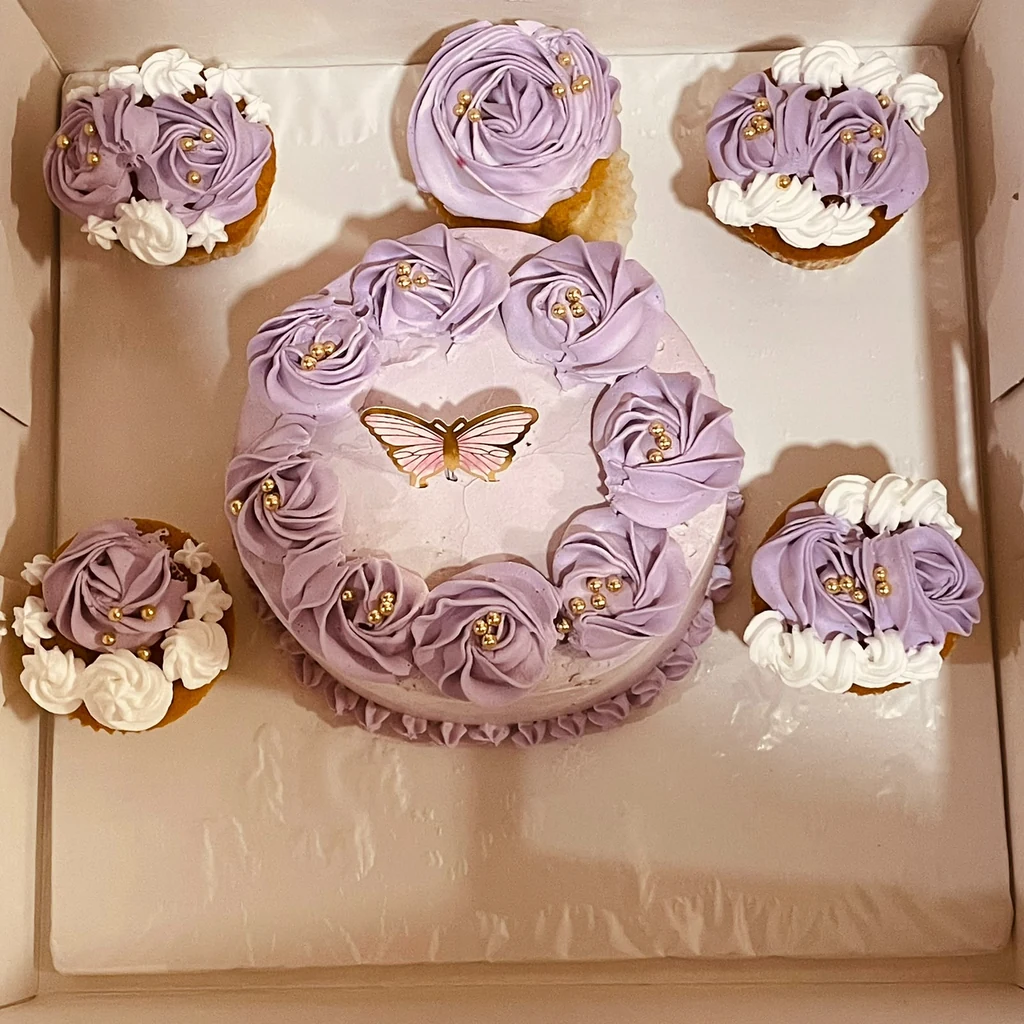 Lavender butterfly cake with gold pearls and four matching lavender and white cupcakes