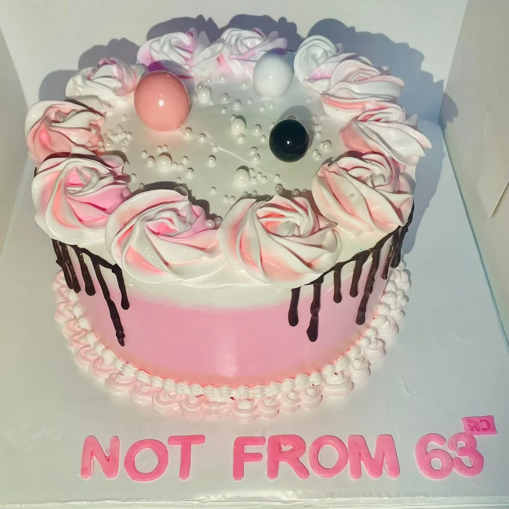 Pink birthday cake with chocolate drip, pink and white rosettes, pearl details and NOT FROM 63 lettering