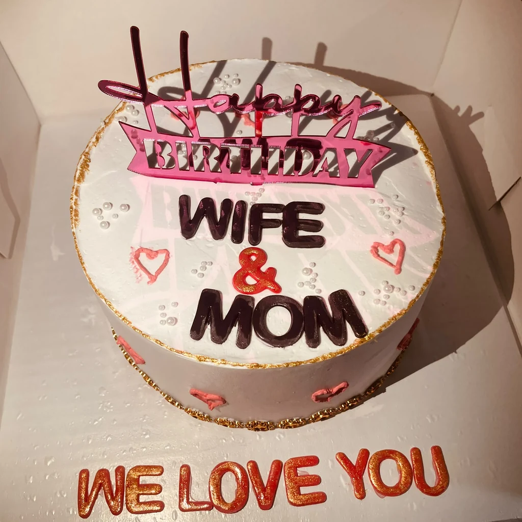 White birthday cake reading Happy Birthday Wife & Mom with red hearts and We Love You message