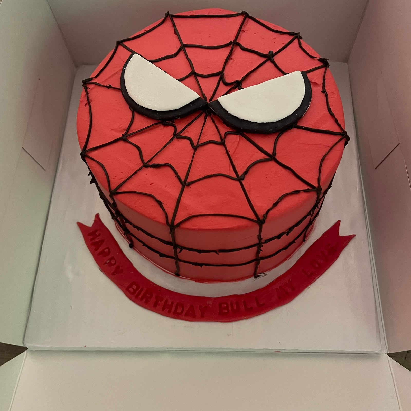 Red Spider-Man face birthday cake with black web piping and white eye panels by Moh Bakes & Treats