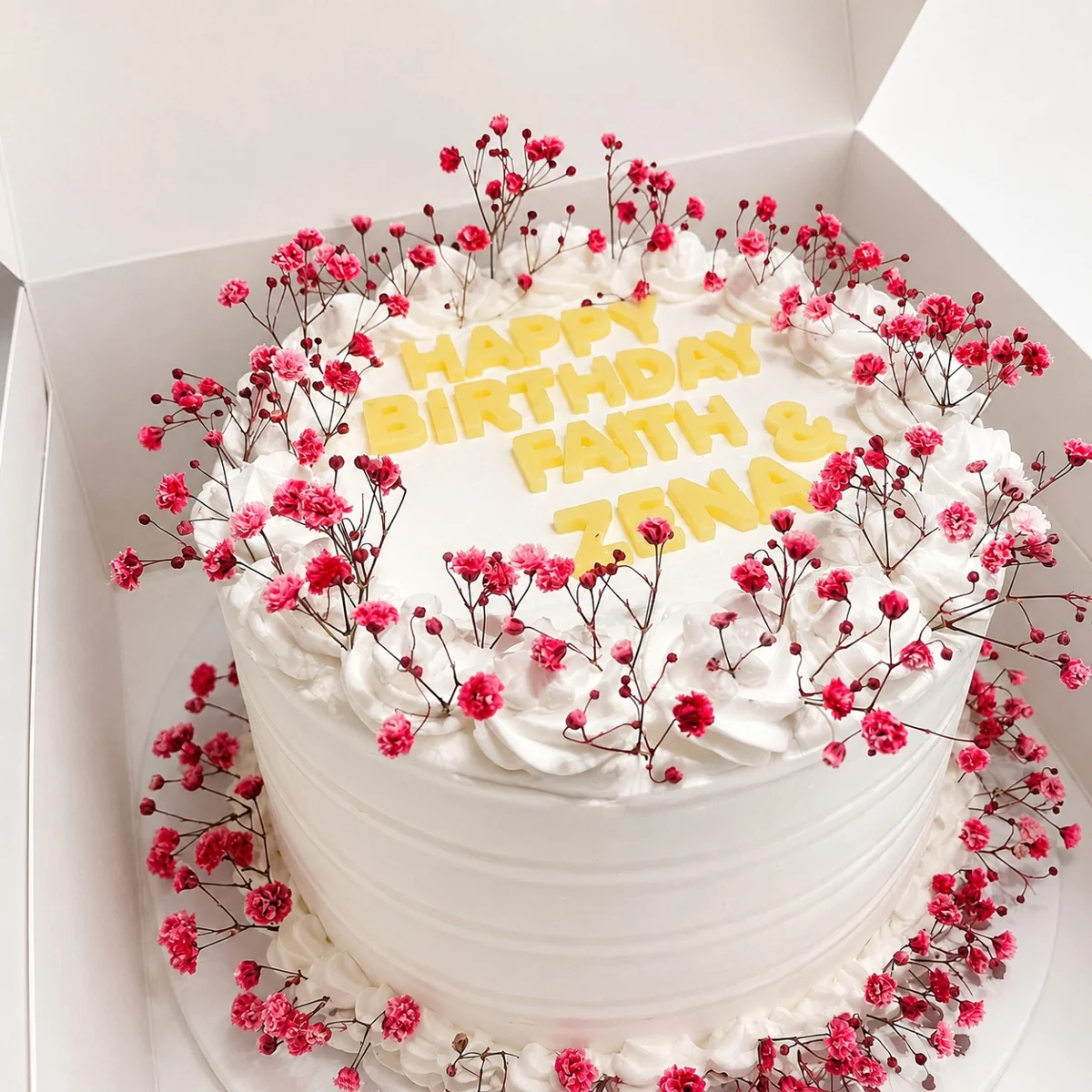 Round floral cake with gold-coloured birthday lettering by Moh Bakes & Treats